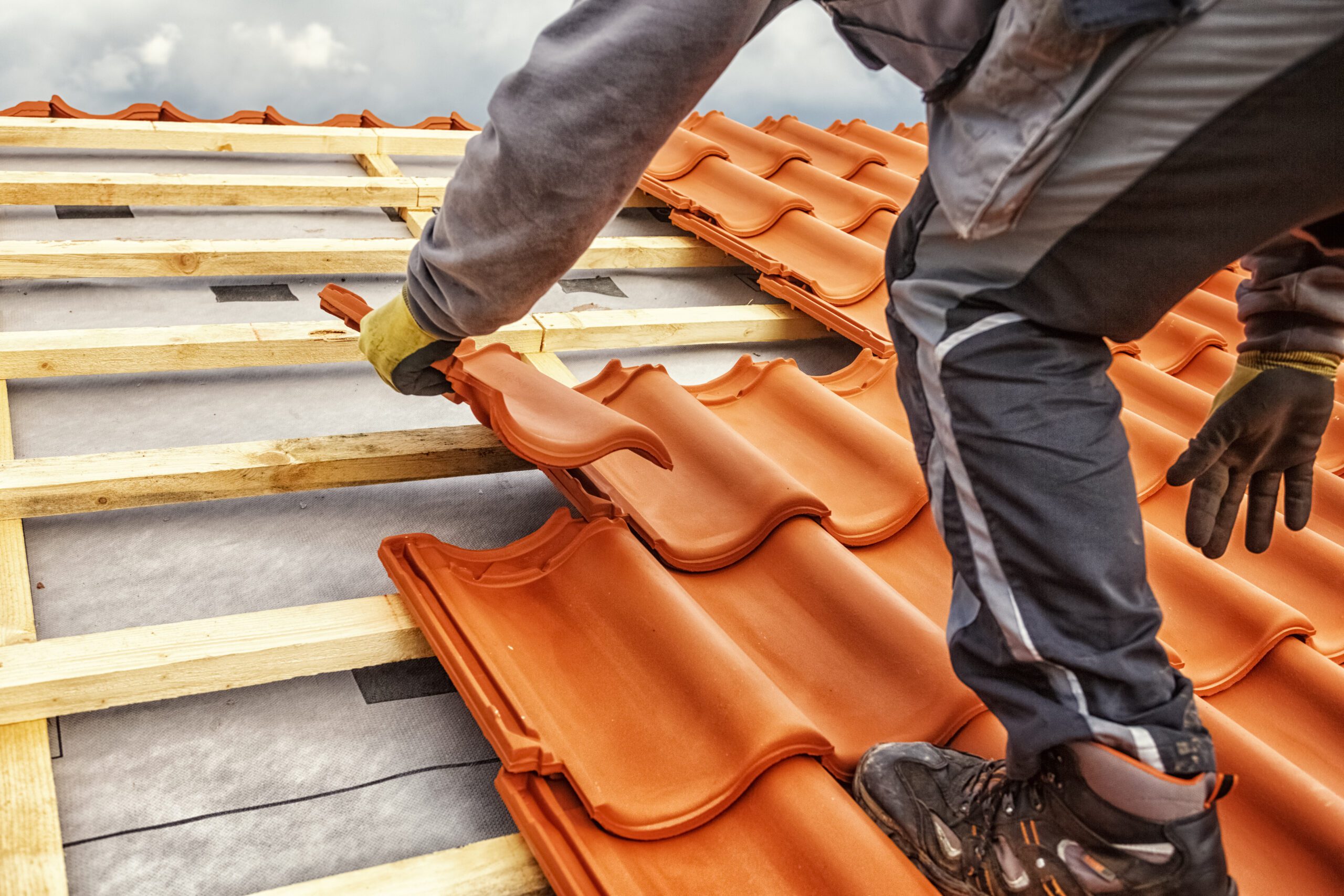 Image of a person laying roofing tiles for roofing companies in Albuquerque